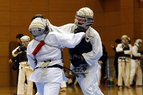 平成21年度日本拳法連盟鏡開き式 赤：冨坂 初段（早稲田大学） vs 白：石澤 2級（日本大学工学部）、石澤の面突き（一本）。はるばる福島県からの参戦で、有段者を相手に2人抜きを果たす。
_MG_1380.JPG
