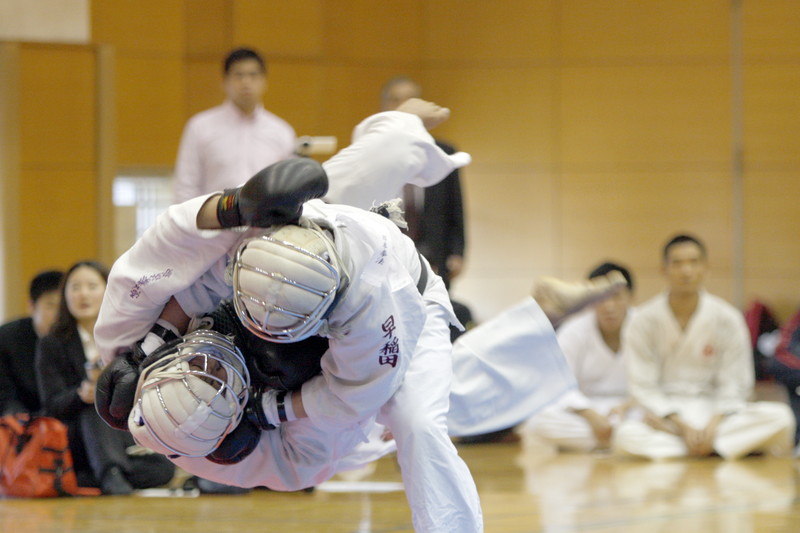 平成27年度日本拳法連盟鏡開き式 段の部、陸自滝ヶ原・奥谷vs早稲田大学・中盾。高橋の投げ→押さえヒザ面蹴り（一本）。
_MG_1965.JPG